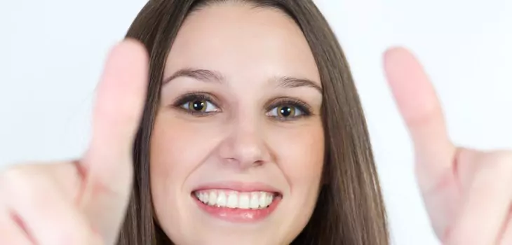 woman with beautiful smile posing thumbs up