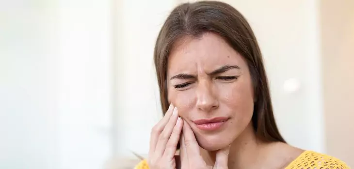 woman looking in pain of sensitive teeth