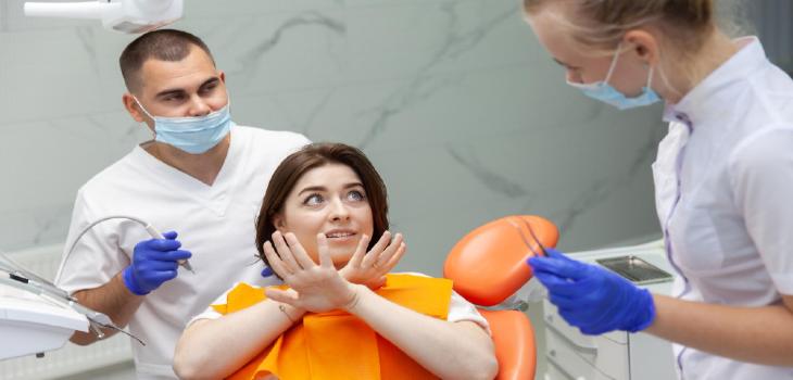 Scared young woman at the dental clinic fear of dentists dental treatment concept