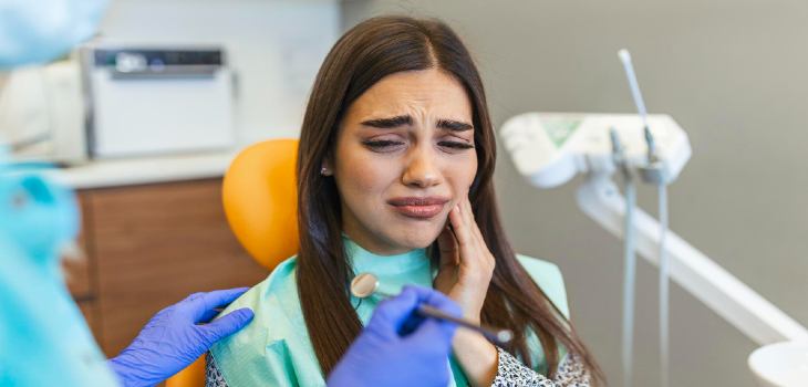 Young woman at dentist having toothache shot of a young woman suffering from toothache while sitting in the dentist s chair