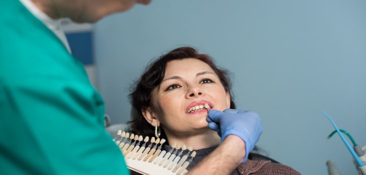 Dentist choosing the teeth color for a patient