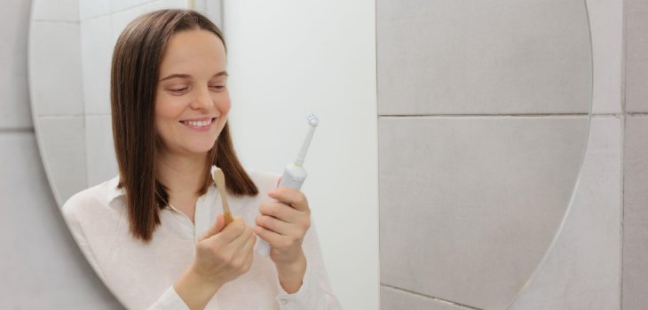 Electric vs manual brushes healthy choices for teeth choosing between manual and electric toothbrushes in bathroom in front of mirror