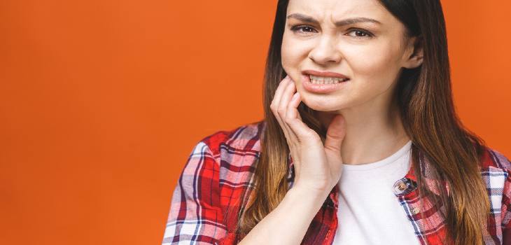 Young woman suffering from severe toothache, feeling strong pain